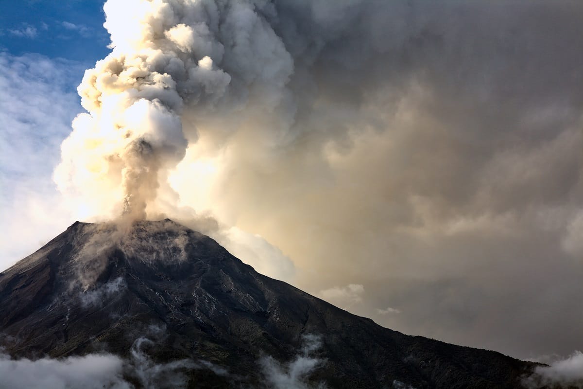 An erupting volcano spewing clouds of ash | Solar geoengineering: Can we buy time to heal climate change?