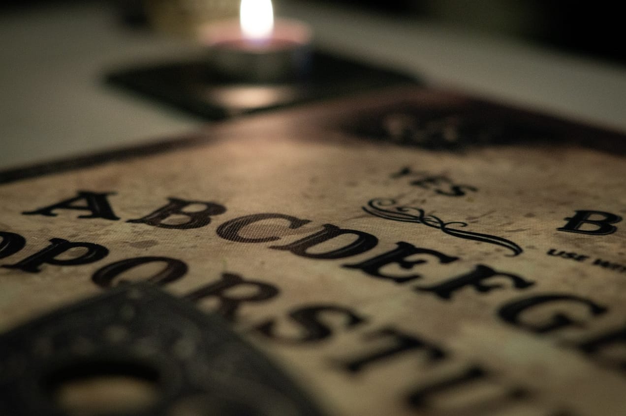 A Ouija board with the pointer visible in the foreground | Why AI isn't an oracle of truth