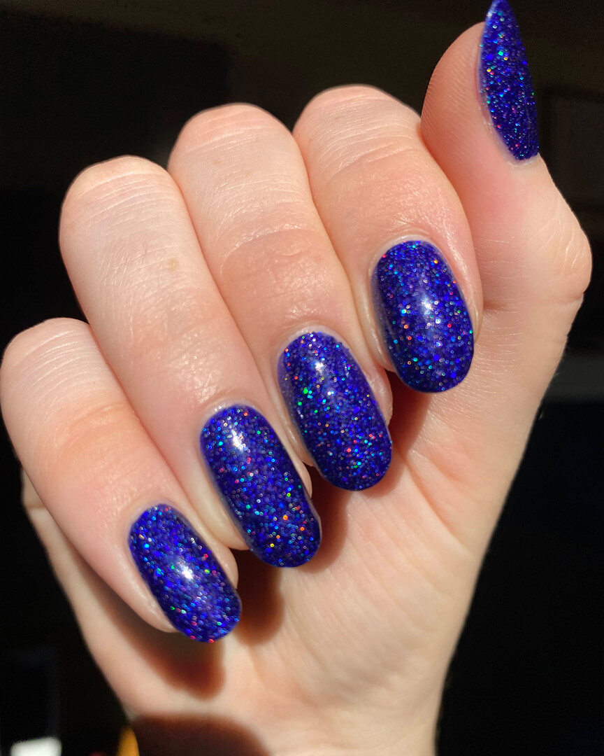 Rebekah is wearing a royal blue glittery holographic nail polish